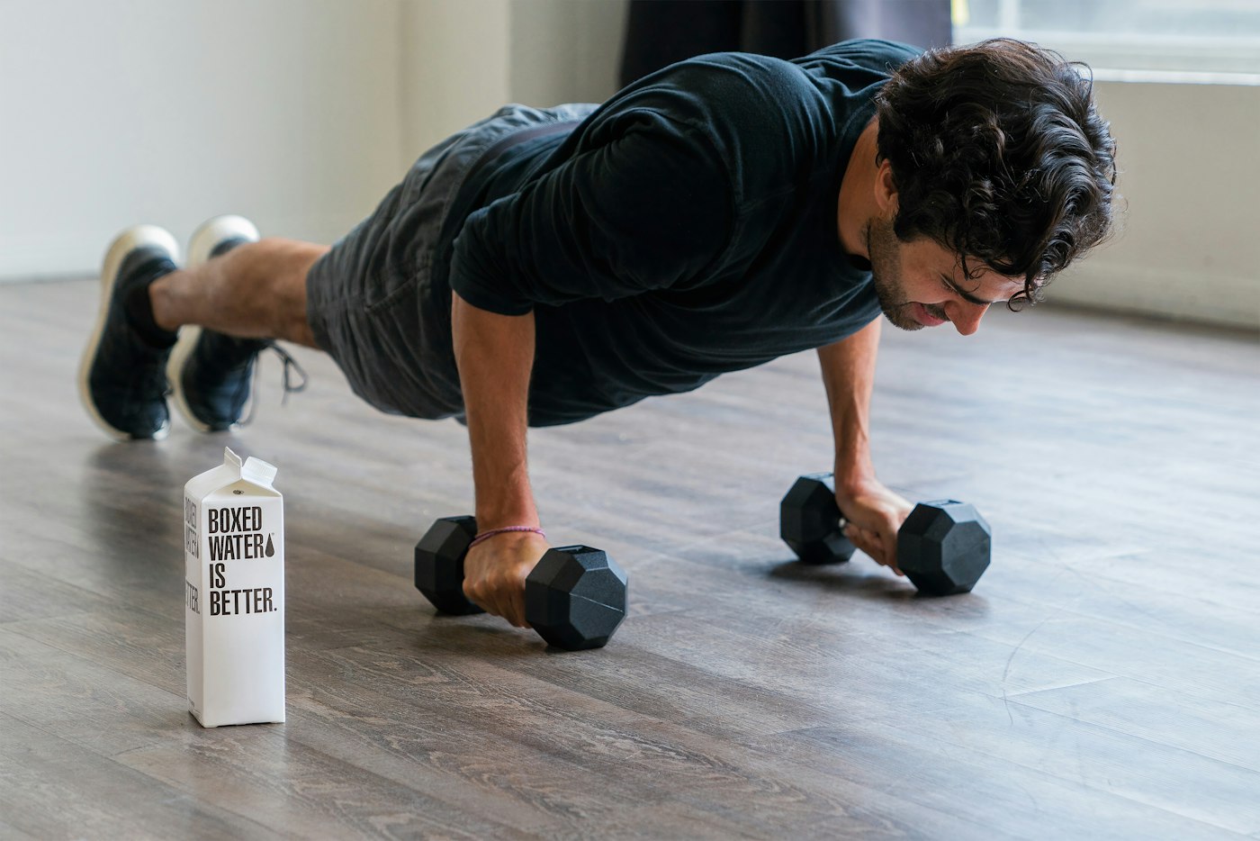 Hombre entrenando en casa con mancuernas