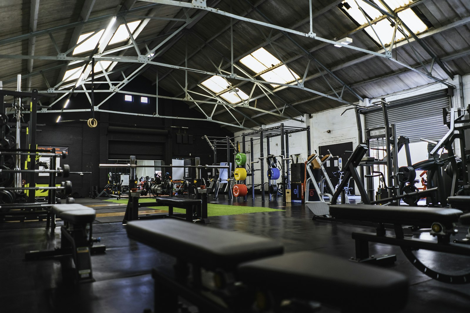 Zona de entrenamiento del estudio con bancos y racks